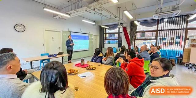 A group of students listen to a presentation on a screen in a classroom during a specialized school workshop at École Française Internationale de Canton(EFIC)