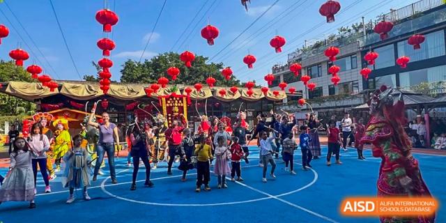 Children and families gather on an outdoor blue court decorated with many red Chinese lanterns at École Française Internationale de Canton(EFIC)