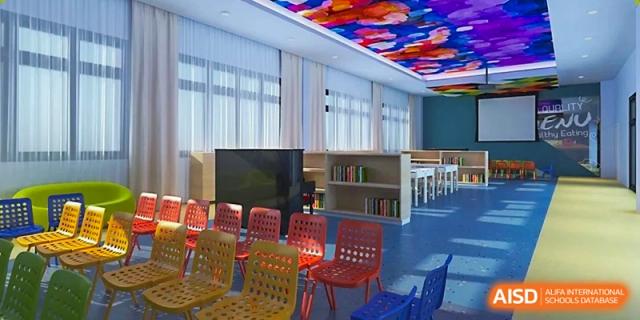 A vibrant student lounge or library features colorful chairs and a view of the outdoors at Beijing International Bilingual Academy Guiyang.
