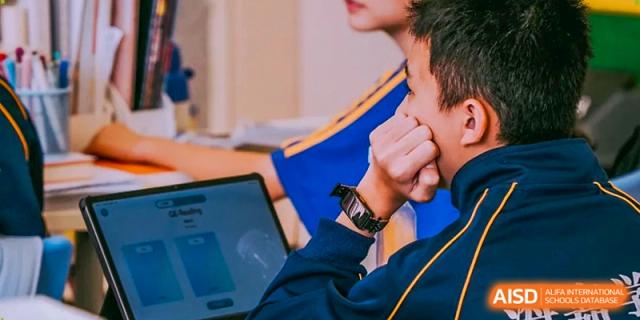 A close-up shot of a student’s hands and a digital tablet during a technology-integrated lesson at Beijing International Bilingual Academy Guiyang.