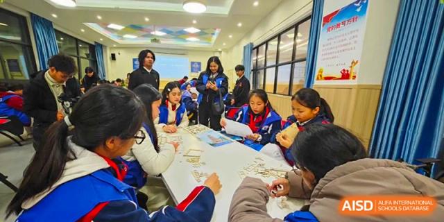 Students sit around a large table, working together on a craft project during an after-school club at Beijing International Bilingual Academy Guiyang.
