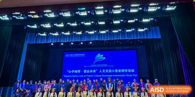 A wide shot of a stage filled with students during a formal performance or awards ceremony at Beijing International Bilingual Academy Guiyang.