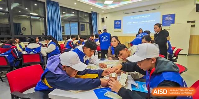 A group of older students collaborates on a science experiment involving various small components at Beijing International Bilingual Academy Guiyang.