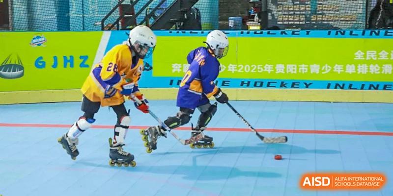 A young hockey player in a purple and yellow uniform maneuvers with a stick on inline skates at Beijing International Bilingual Academy Guiyang.
