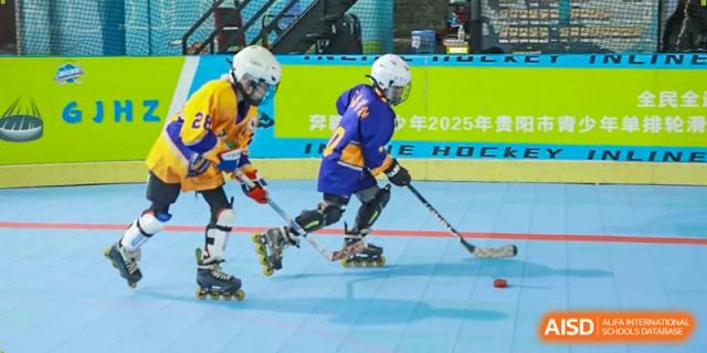 A young hockey player in a purple and yellow uniform maneuvers with a stick on inline skates at Beijing International Bilingual Academy Guiyang.