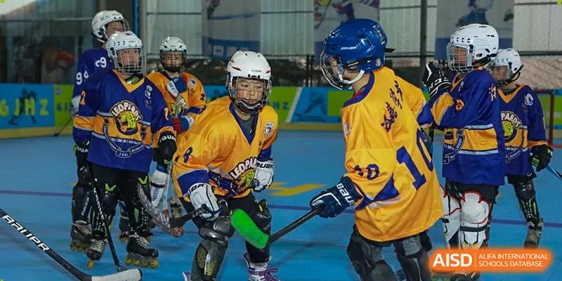 Young athletes in vibrant team jerseys engage in a competitive hockey game at Beijing International Bilingual Academy Guiyang.