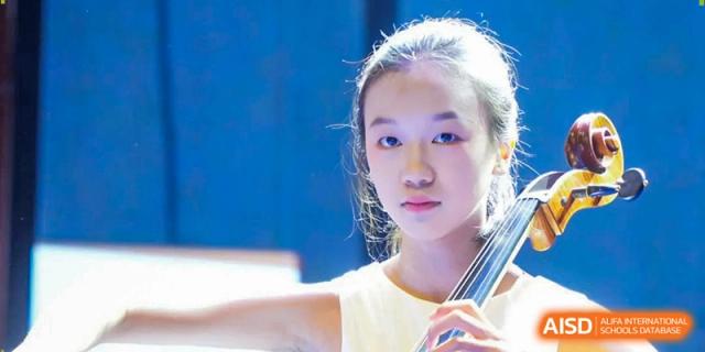 Close-up of a young female student with focused expression during a musical performance at Beijing International Bilingual Academy Guiyang.