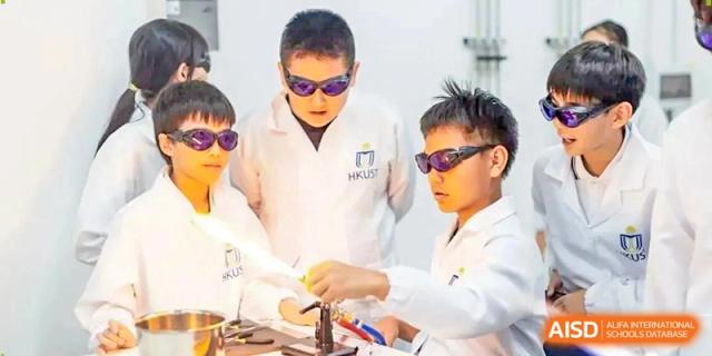 Students wearing protective lab goggles perform a hands-on science experiment in a modern laboratory at Benenden Bilingual School Guangzhou