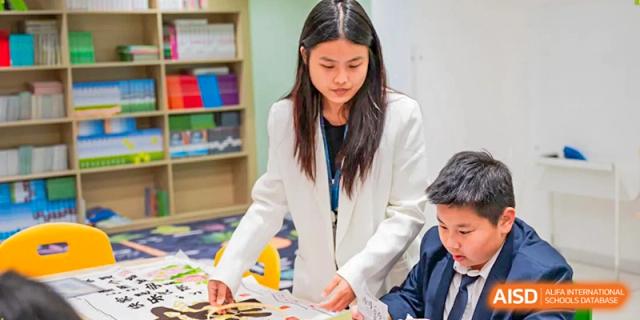 A female student in a white lab coat carefully reviews documents during a science-based classroom lesson at Benenden Bilingual School Guangzhou