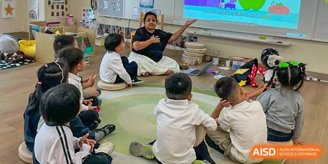 A teacher leads a storytelling or discussion session with students sitting on a rug in a bright classroom at Benenden Bilingual School Guangzhou
