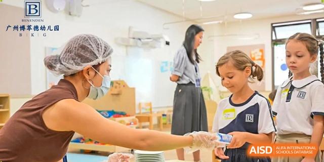 A student receives a gentle health check or assistance from school staff in a clean and bright classroom setting at Benenden Bilingual School Guangzhou