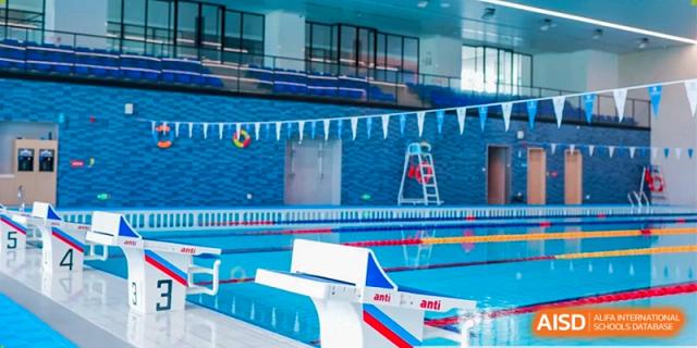 A modern indoor competitive swimming pool with clearly marked lap lanes and blue tiled walls at Benenden Bilingual School Guangzhou