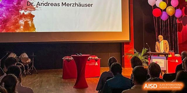 An empty stage with a red podium stands ready for a formal graduation ceremony or presentation. Deutsche Botschaftsschule Peking