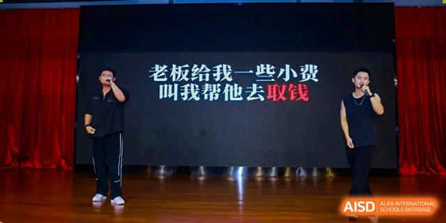 A black screen displaying white and red Chinese text above a wooden floor at Maple Leaf International Schools - Hainan