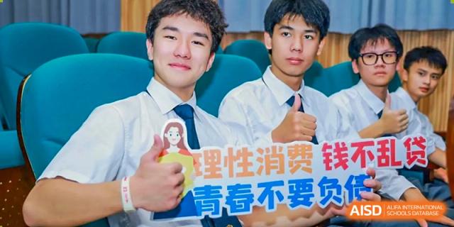 Two male students in white shirts and ties smiling while holding a colorful sign at Maple Leaf International Schools - Hainan