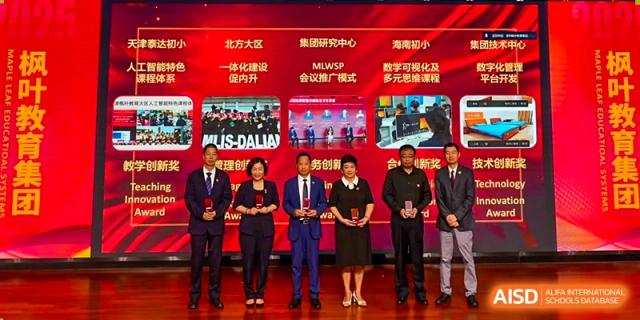 Five school officials standing on a stage in front of a red digital backdrop during an award ceremony at Maple Leaf International Schools - Hainan