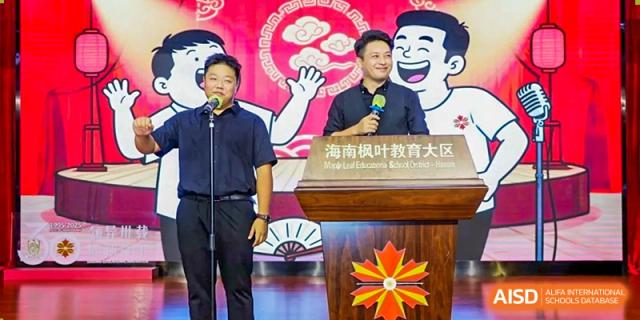 Two men speaking at a wooden podium decorated with a red maple leaf logo during a school event at Maple Leaf International Schools - Hainan