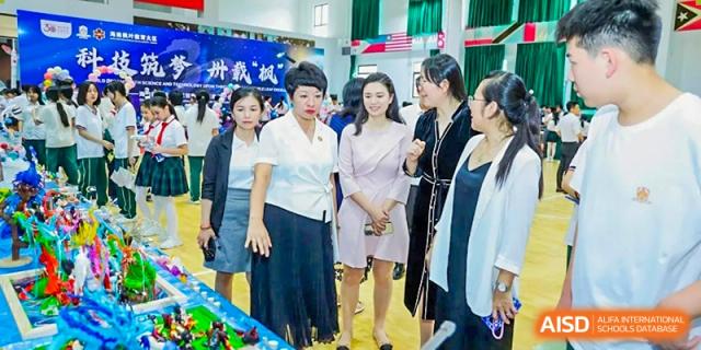 A group of women in professional dress talking together at a formal school gathering or exhibition at Maple Leaf International Schools - Hainan