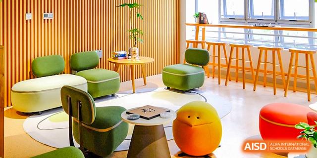 A vibrant student common area with colorful modular seating, small tables, and a board game ready for play at Guangzhou ULink International School.