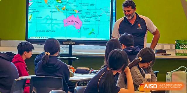Students in a classroom looking at a digital screen showing a map of Australia during a geography or social studies lesson at Guangzhou ULink International School.
