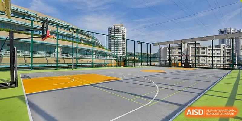 A high-angle view of a professional outdoor basketball and sports court surrounded by safety fencing and city views at Guangzhou ULink International School.