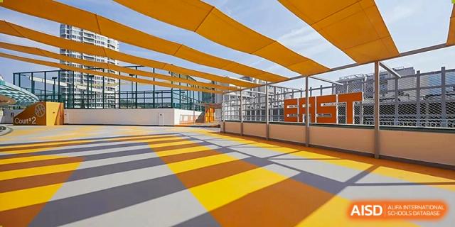 An outdoor multi-purpose sports court featuring vibrant yellow and orange sunshades and a patterned ground design at Guangzhou ULink International School.