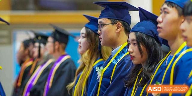 A profile view of a male student in a blue graduation gown and cap looking forward during a ceremony at Yew Wah International Education School of Guangzhou