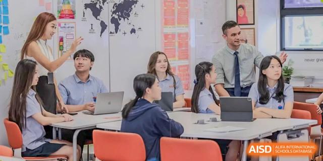 A group of students sit around a table and engage in a collaborative group project in class at Yew Wah International Education School of Guangzhou