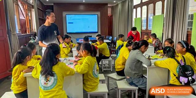 A teacher leads a digital literacy lesson, using an interactive whiteboard to help students understand complex information in a modern lab at Beanstalk International Bilingual School Shunyi Campus.