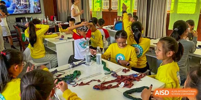 Students engage in a creative textile workshop, working with red fabrics and materials to create unique handmade projects at Beanstalk International Bilingual School Shunyi Campus.