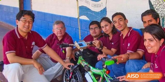 Students and staff pose with a green bicycle during a community project or sustainability initiative focused on practical life skills at Beanstalk International Bilingual School Shunyi Campus.