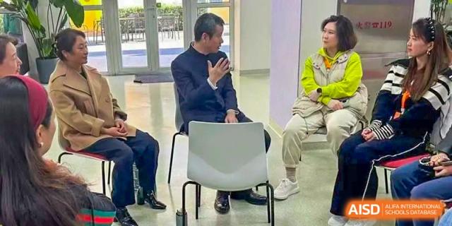 Faculty members sit in a circle for a collaborative meeting, engaging in open dialogue about school initiatives and student progress at Beanstalk International Bilingual School Shunyi Campus.