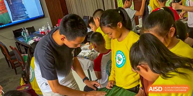 A teacher guides a student through a hands-on activity, providing personalized support during a creative and practical learning lesson at Beanstalk International Bilingual School Shunyi Campus.