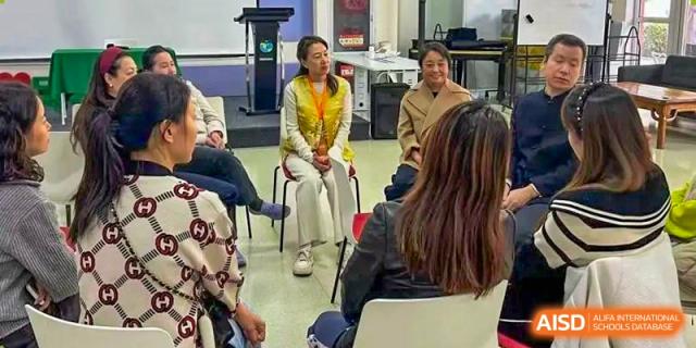 A group of educators sits in a circle for a focused workshop, sharing insights and collaborating on upcoming curriculum goals at Beanstalk International Bilingual School Shunyi Campus.