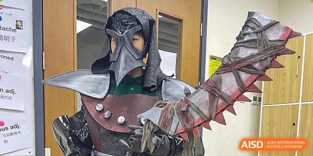 A student displays an elaborate and detailed fantasy warrior costume featuring a dark mask and silver armor during a creative costume design workshop at Beanstalk International Bilingual School Shunyi Campus.