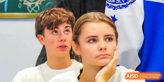 Two students listen intently with thoughtful expressions during an academic lecture or classroom presentation held in a bright learning space at Beijing LuHe International Academy.