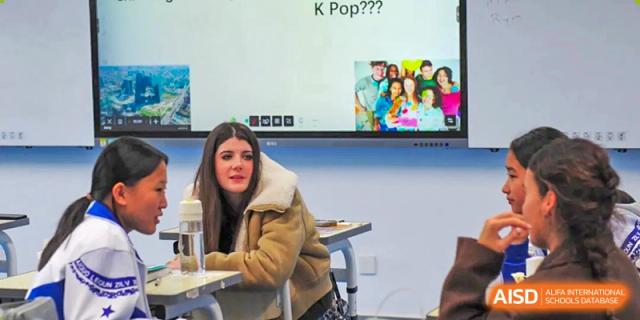 Students engage in a lively classroom discussion centered around a digital presentation about global pop culture trends at Beijing LuHe International Academy.