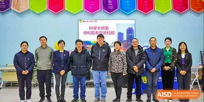 A group of school administrators and distinguished guests pose together for a formal group photograph in front of a colorful banner during a campus event at Beijing LuHe International Academy.