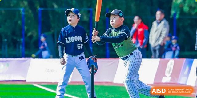 Two young baseball players in full gear stand ready on the field, showcasing teamwork and sportsmanship during a competitive youth baseball game at Beijing Tongzhou Shuren Private School.