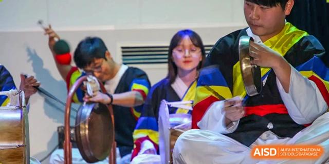 Students dressed in traditional Korean Hanbok perform with cultural musical instruments, including a gong and drum, during a ceremony at the Korean International School In Beijing.