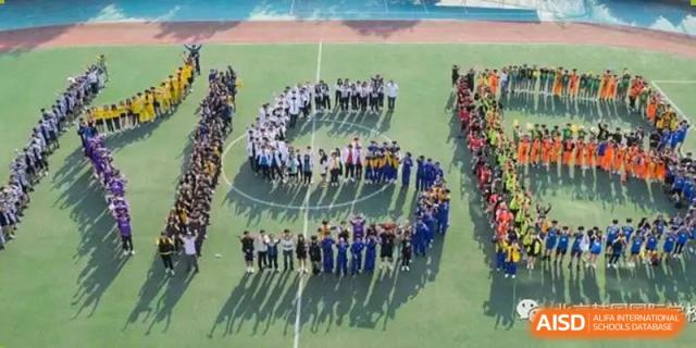 An aerial view shows students on a green field standing in a formation that spells out "KISB" during a special commemorative event at the Korean International School In Beijing.
