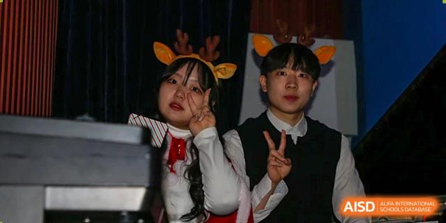 Two students in festive costumes smile and pose with peace signs for the camera at Korean International School In Beijing.