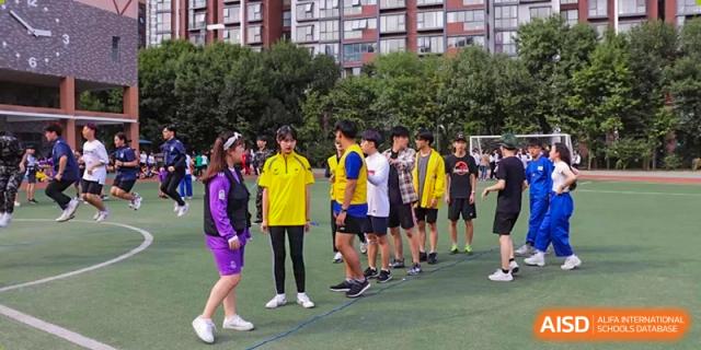 wo students in black vests labeled Student Council play a competitive match of table tennis while others watch from the sidelines at the Korean International School In Beijing.