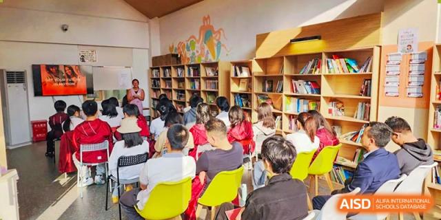 A large group of students sits in a library or media center during an engaging group discussion at Griffin International Academy.