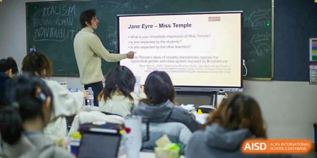A teacher uses a digital screen to present a lesson on literature to a class of focused students at Griffin International Academy.