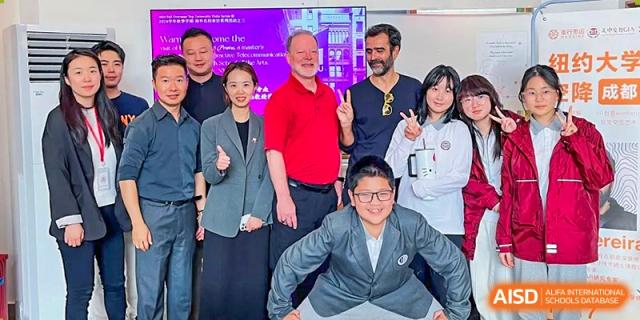 A group of students and faculty members smile and pose together for a celebratory indoor photo at Griffin International Academy.