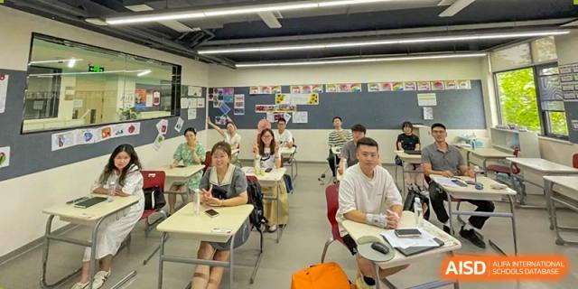 A teacher uses a large digital screen to present a lesson on literature to a class of attentive students at Griffin International Academy.