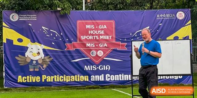 A large purple banner for the "MIS GIA House Sports Meet" is displayed outdoors against a backdrop of green trees at Griffin International Academy.