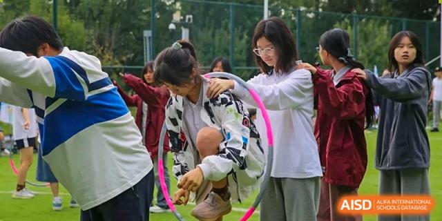 A female student focuses as she steps through a colorful hula hoop during a field day relay race at Griffin International Academy.