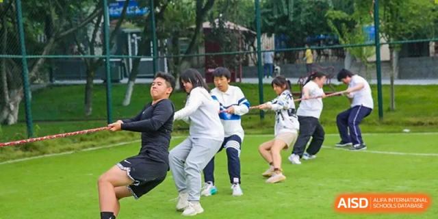 A group of students pulls with all their might during an intense outdoor tug-of-war match at Griffin International Academy.